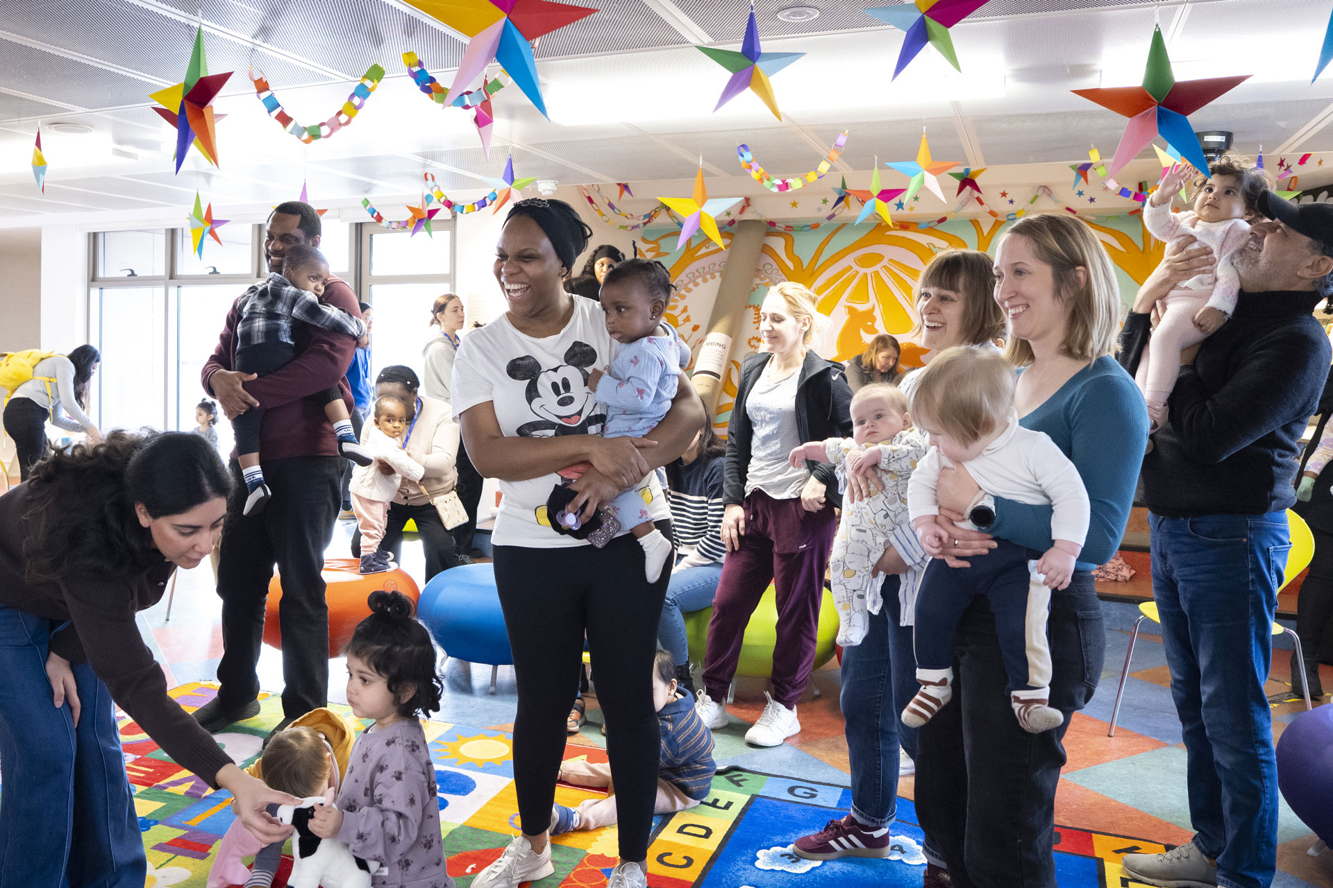 Parents and carers with babies and toddlers taking part in a Rhyme Time session at Canada Water Library.